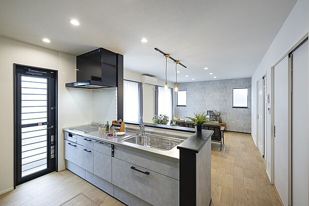 【1階キッチン/当社施工例】キッチンはLDへ視界が広がり開放感◎リビングのクロスと統一感があり、濃いカラーの笠木が空間全体のアクセントに。/建物価格1952.3万円、建物面積91.08m2、3LDK