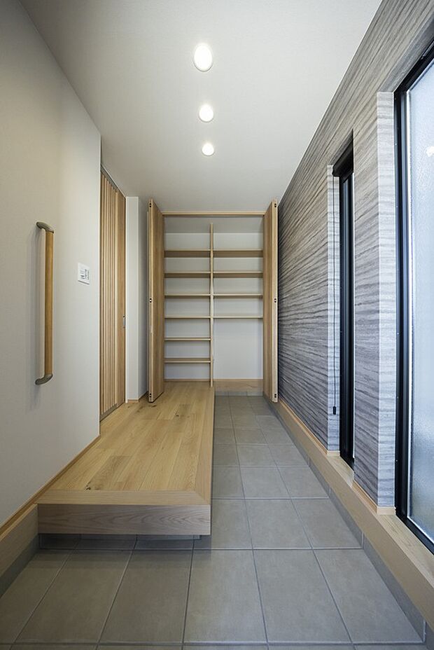 【【1階玄関/当社施工例】】2連のFIX窓から伸びやかな自然光が注ぐ、ゆとりあるエントランスです。玄関框が長く、フロートタイプのため、靴を出したままでもスッキリ。/建物価格:2504.5万円、建物面積95.22m2、4LDK