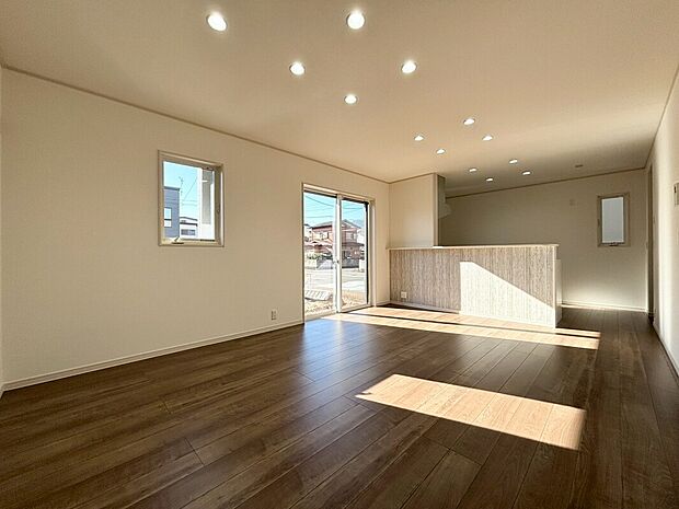 【【B号棟:リビング】】16帖の開放感のあるLDK。窓からたっぷりと自然光が差し込む、心地よいリビングダイニング。温かみのある床材が落ち着いた雰囲気を生み出し、家具やインテリアを上品に引き立てます。