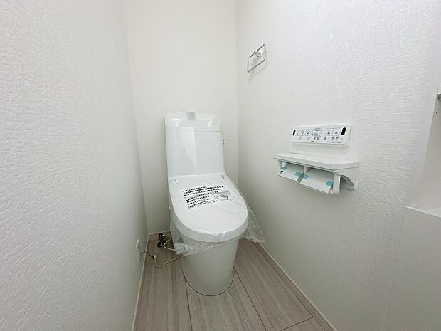 【【6号棟:トイレ】】フチレス形状やお掃除リフトアップ機能などお手入れのしやすさが特徴。
壁設置型のリモコンと2連紙巻き器が備え付けとなっている超節水タイプの温水洗浄便座です。(2026年1月26日撮影)