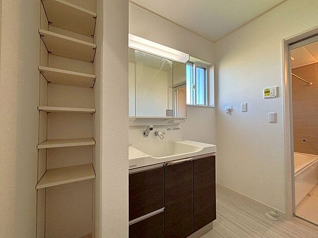 【【洗面室】】壁から水栓などが出ている為水滴が溜まらずお掃除も簡単です。鏡裏収納の中央の金網部分では濡れたコップなどが乾かせる優れものです。物入は可動棚付きです。高さが変えられる便利な収納です。