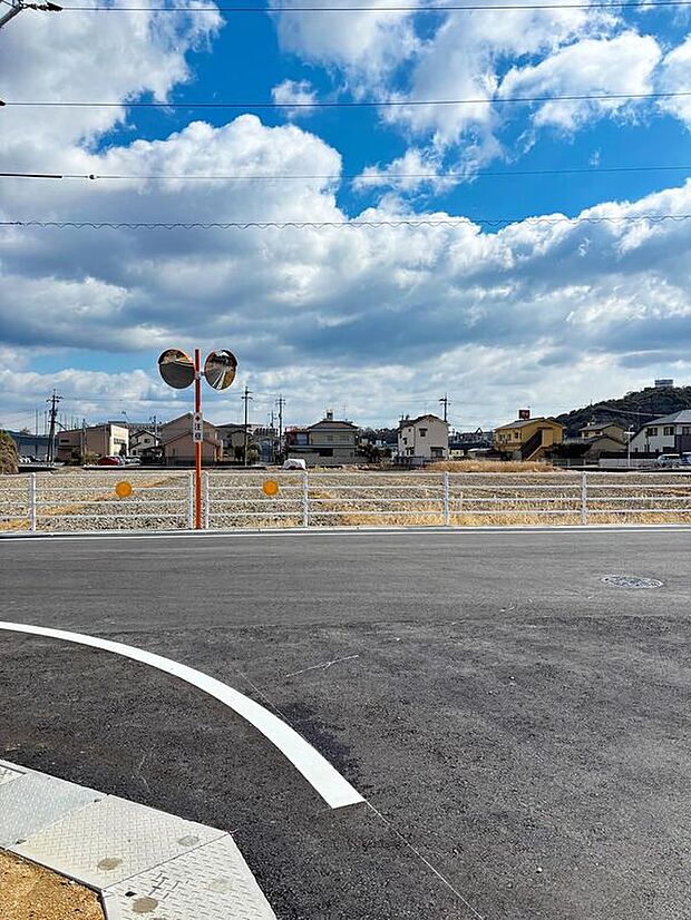 【現地土地写真】分譲地入口付近の交差点には安全のためのミラーや路側帯を設置。(2025年2月)撮影