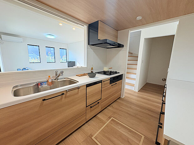 【キッチン】温かみのあるキッチンカラーと下がり天井のアクセントクロスが、空間に心地よい統一感を与えます。自然と家族が集まるキッチンです。