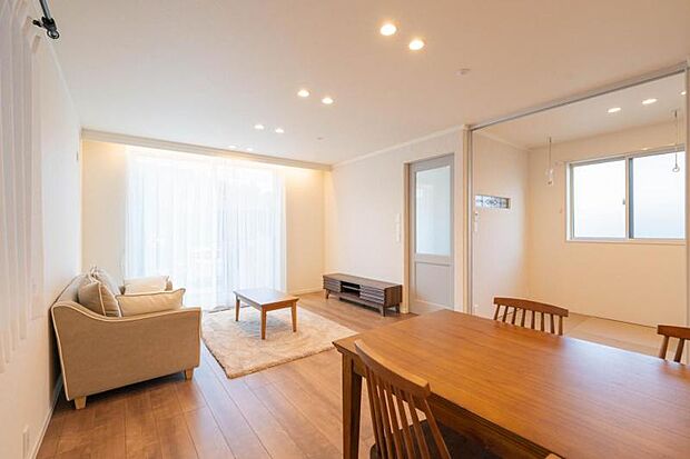 大きな窓から明るい陽ざしが降り注ぐLDK。窓を開ければ庭とつながり◎