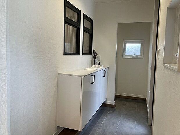 【洗面】C棟玄関/玄関を開けると、デザイン小窓がお出迎え。2方向から上がれる便利な動線も魅力的。(2026年5月撮影)
