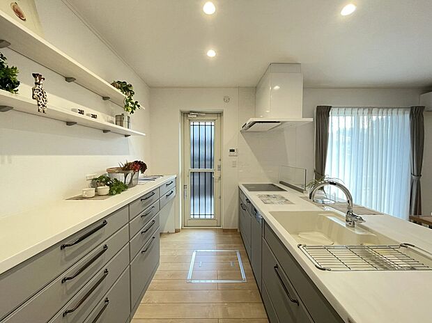 【9号地キッチン】豊富な収納と広々ワークトップで、お料理がもっと楽しく。勝手口付きでゴミ出しもスムーズです。お気に入りを飾れる棚もあり、機能性とデザインを両立した空間です。