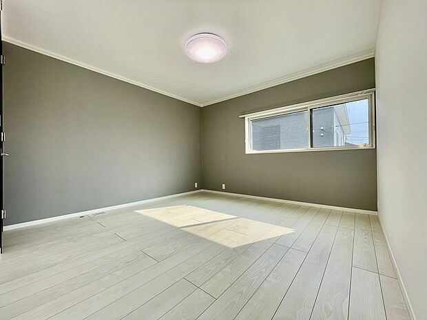 【主寝室】落ち着いたグレーのアクセントクロスが心地よい主寝室。9.3畳のゆとりある広さに加え、大きな窓からやわらかな光が差し込みます。一日の終わりをゆったり過ごせる、落ち着きある空間です。