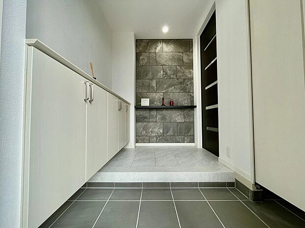 【玄関】石目調のアクセントウォールが印象的な、落ち着きある玄関空間。フロートタイプのシューズボックスで収納力もあり、すっきり保てます。デザインと使いやすさを兼ね備えた、心地よいエントランスです。