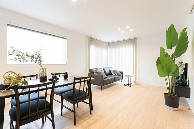 窓から豊かな陽光と風が広がり、家族がゆったりとくつろげる居心地の良いリビングです。