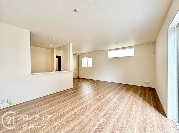 ナチュラルな木目調のフローリングと落ち着いたトーンのクロスが調和したリビング。大きな掃き出し窓が開放感を演出し、外の風景と心地よくつながります。家族との時間も一人の時間も楽しめる理想的な居住空間です。