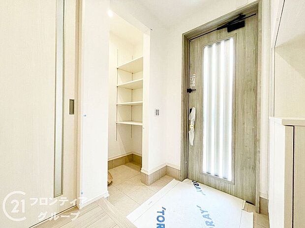 【玄関】光を取り込むドアと淡いタイル張りの玄関が、温もりと清潔感を両立。シューズボックスもたっぷりサイズで、ご家族全員の靴がすっきり収まります。毎日の出入りが楽しくなる、気持ちのよい玄関空間です。