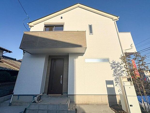 青空に映える、白を基調としたモダンな外観の住まい。家族の笑顔が溢れる新生活をここから始めませんか。