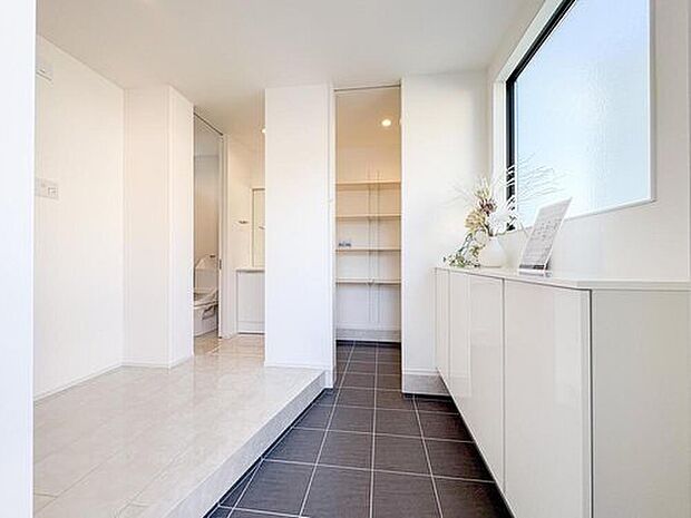 【玄関】広々とした玄関は、家族の靴やベビーカーもゆったり置けるゆとりある空間。大容量の収納で、いつもスッキリと片付き、明るい光が差し込みます。