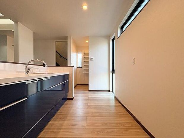 【キッチン】洗練されたネイビーキッチン！換気窓や食洗機も完備。キッチン奥には収納棚付きのパントリーが。