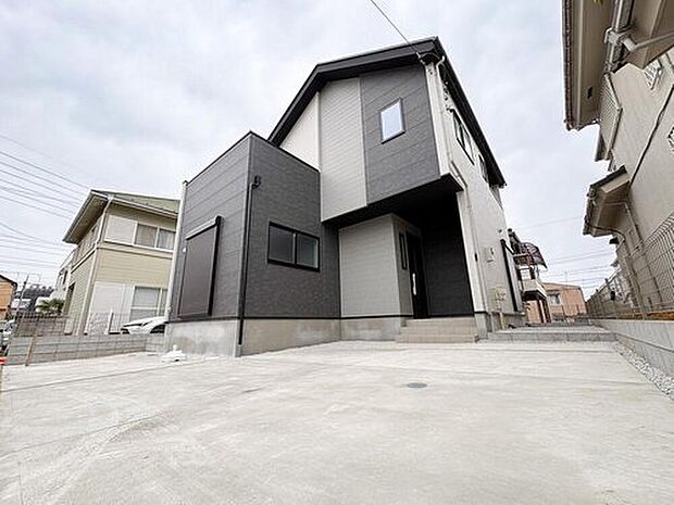 【現地外観写真】空に映えるシャープなシルエット。カースペースは広々としており、大型車の駐車や自転車置き場にも十分。