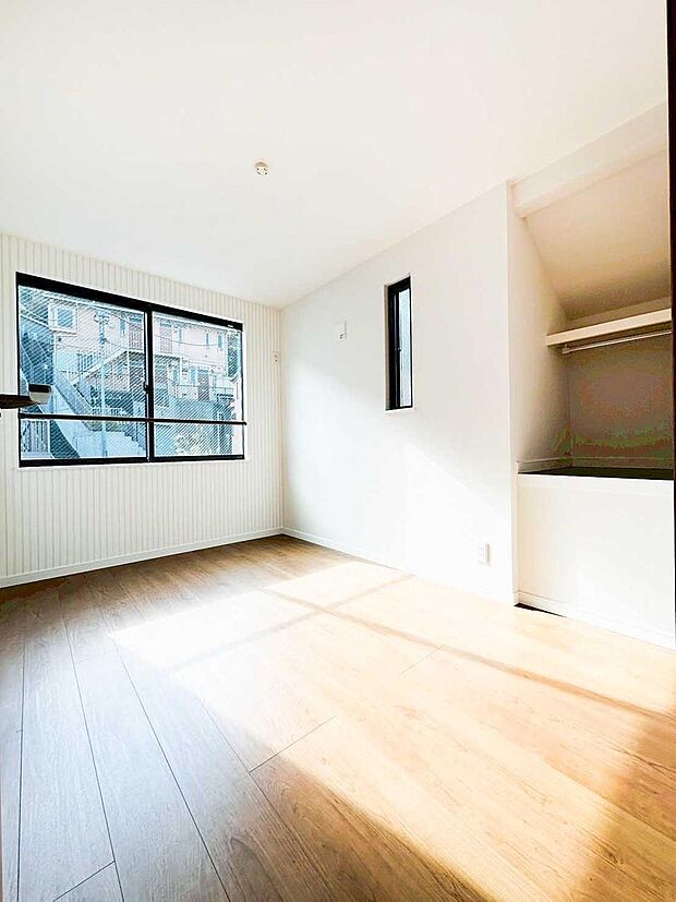 【リビング以外の居室】大きな窓から光が差し込む明るい洋室。オープンクローゼット付きで整理整頓がしやすく、室内を広く使えます。縦ラインのアクセント壁が空間に表情を加える、使い勝手の良い一室です。