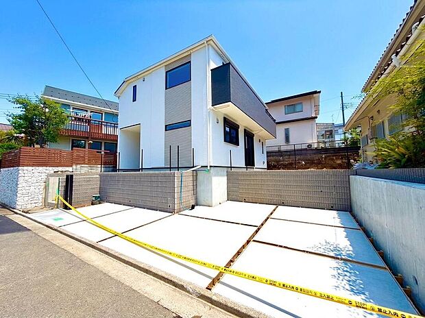 青空に映える白と黒のコントラストが美しい、モダンな新築戸建てです。広々とした駐車スペースは、家族の車を複数台停められ、来客時も安心。新しい暮らしがここから始まります。