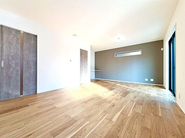 【リビング】明るい陽光が降り注ぐ広々としたリビングは、家族の笑顔と会話が弾む空間。木のぬくもりを感じるフローリングで、お子様も安心してのびのびと過ごせます。