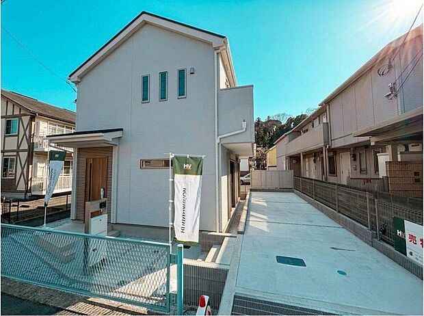 【現地外観写真】青空に映えるスタイリッシュな外観の戸建てです。広々とした駐車スペースは、家族の車での外出をスムーズにし、日々の暮らしを快適にします。