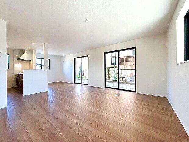 【リビング】家族の絆を育む、光あふれる広々リビング。大きな窓から明るい陽射しが差し込み、奥のキッチンからは家族の様子が見守れます。