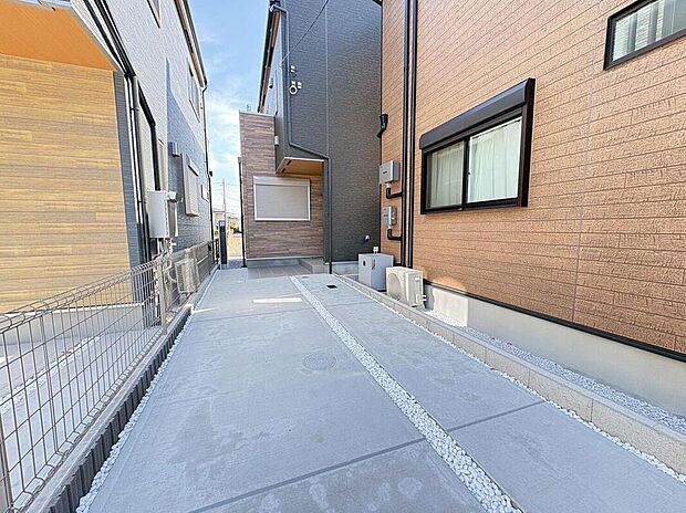 【駐車場】コンクリートと白い小石のラインが美しい、広々とした駐車スペース。車の出し入れもスムーズで、日々の送迎やお買い物も快適にサポートします。
