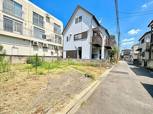 【前面道路含む現地写真】青空が広がる閑静な住宅街に佇む、白壁が美しい一戸建て。陽光降り注ぐ明るい環境で、家族の穏やかな毎日を育めます。