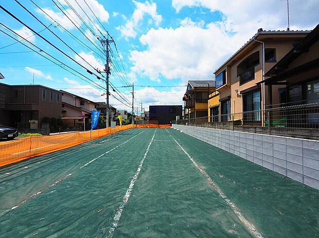 【現地土地写真】建築条件付き土地には、「自由度」と「コスト」のバランスが取れた魅力があります新しい暮らしが始まる予感に満ちた、広々とした敷地。周辺は穏やかな住宅街で、子育て世代にも安心の住環境です。青空の下、家族の夢
