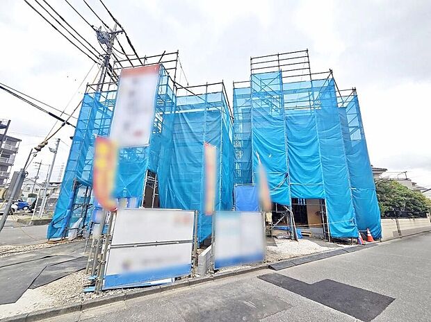 【現地外観写真】現地(2026年8月)撮影
青い養生ネットで覆われた建築中の外観写真。全2棟、完成予定2026年10月。前面道路は幅4~6m、駐車は1号棟2台・2号棟1台です。