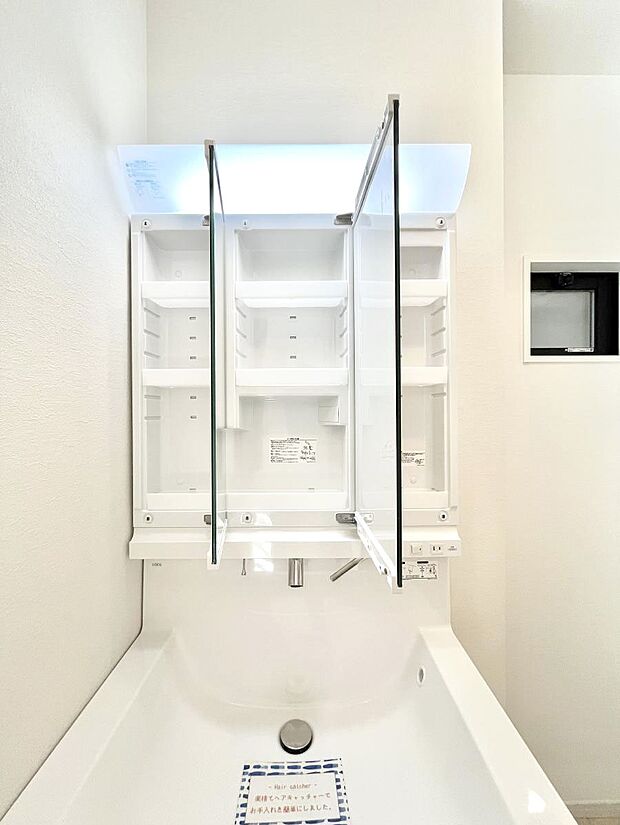 【その他設備(三面鏡裏収納)】三面鏡の裏に、化粧品や衛生用品などを収納可能。洗面台をすっきりと保ちます！