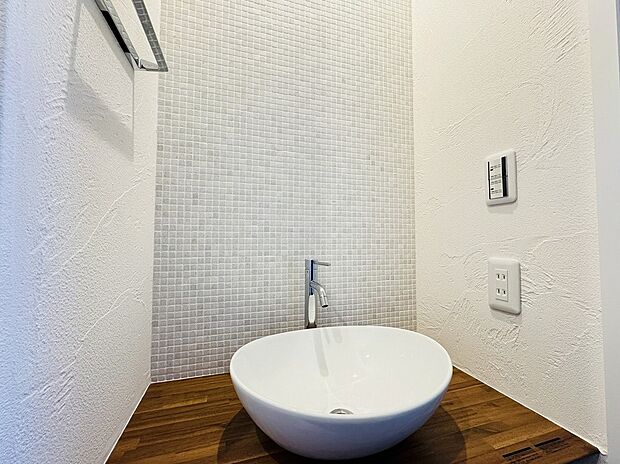 【-】メインの洗面室とは別に、玄関を入ってすぐのところにセカンド洗面台を設置。コロンとしたかわいらしい小型の洗面ボウルは、外から帰ってきてすぐに手洗いとうがいができるので、小スペースながら機能的！ウイルスはドアノブから感染につながることもあり、風邪や感染症などの予防になり、いつでも清潔な状態で室内へ。遊んで帰ってきた子供も自然と手洗いが習慣化され、来客時にはわざわざ洗面室を使って頂かなくて済みます。また、壁に施されたモザイクタイルは、遊び心が溢れるデザインでインテリアとしても楽しめると人気です。