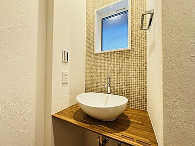 メインの洗面室とは別に、玄関を入ってすぐのところにセカンド洗面台を設置。コロンとしたかわいらしい小型の洗面ボウルは、外から帰ってきてすぐに手洗いとうがいができるので、小スペースながら機能的！ウイルスはドアノブから感染につながることもあり、風邪や感染症などの予防になり、いつでも清潔な状態で室内へ。遊んで帰ってきた子供も自然と手洗いが習慣化され、来客時にはわざわざ洗面室を使って頂かなくて済みます。また、壁に施されたモザイクタイルは、遊び心が溢れるデザインでインテリアとしても楽しめると人気です。 