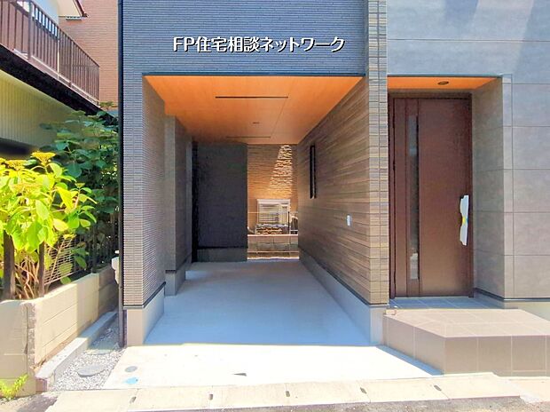 【現地外観写真】開放的なエントランスと落ち着いた外壁が魅力のモダン住宅。ご家族の未来を彩る一戸建てです。