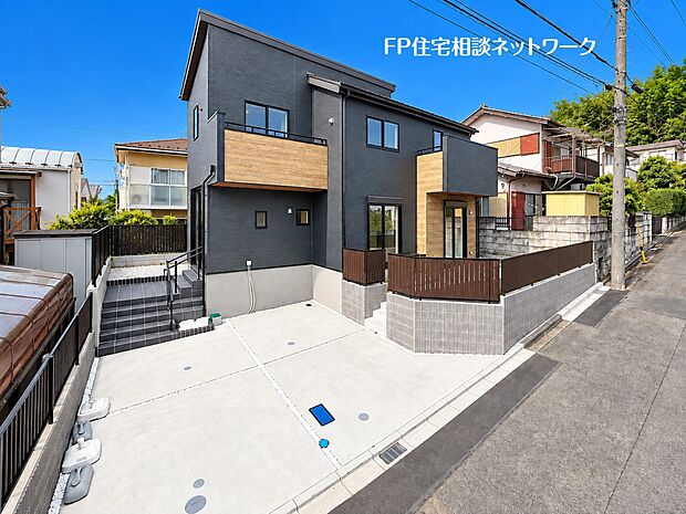 ブラックを基調としたスタイリッシュな外観に、木目調のアクセントが映えるデザイン住宅。ゆとりある並列2台のカースペースを確保した贅沢な広さです。