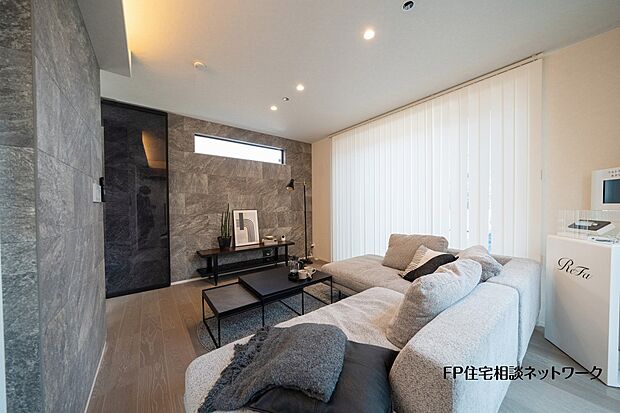【内観】【プラン例　建物価格2480万円　建物面積100m2】石目調のアクセントウォールが印象的なリビング。落ち着いた色合いでまとめ、ゆったりくつろげる空間に仕上げました。
