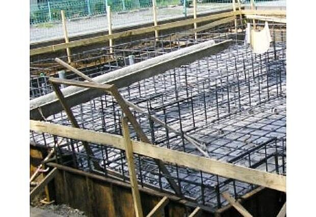 【ベタ基礎】ベタ基礎は、コンクリートで建物の下一面を支える工法。基礎鉄筋を張り強度を強めたベタ基礎の耐圧盤を1階の床下全面に施工し、広い耐圧盤の面で建物の荷重を地盤に伝えます。