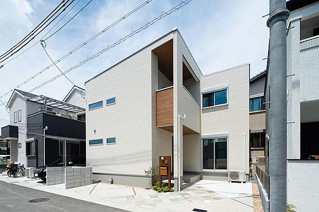 【【当社施工例/外観】】明るいカラーの外壁をメインに、一部木目調を施したナチュラルなデザインです。おしゃれなデザイン門柱やグリーンで豊かな住まいを演出しています。