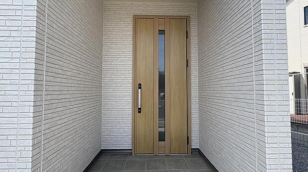 【【玄関/1号地モデルハウス】】奥行きにゆとりがある、明るい色調の玄関ポーチ。雨の日にお子様を抱っこしたまま鍵を探したり、ベビーカーを一時的に置いたりと、毎日の外出や帰宅をスムーズにサポートします。