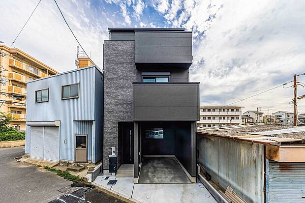 当社施工実例（外観）
石目調のサイディングとマットなブラックパネル。異なるテクスチャを組み合わせることで、シンプルなボックスシルエットに深い奥行きを与えました。
