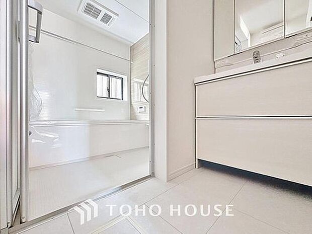 【洗面台・洗面所】明るく清潔感のある色調で纏められた洗面室は、機能性に富んだ三面鏡と使い勝手の良い収納を完備した洗面台を設置。洗濯機置場も完備し、大変充実しております。