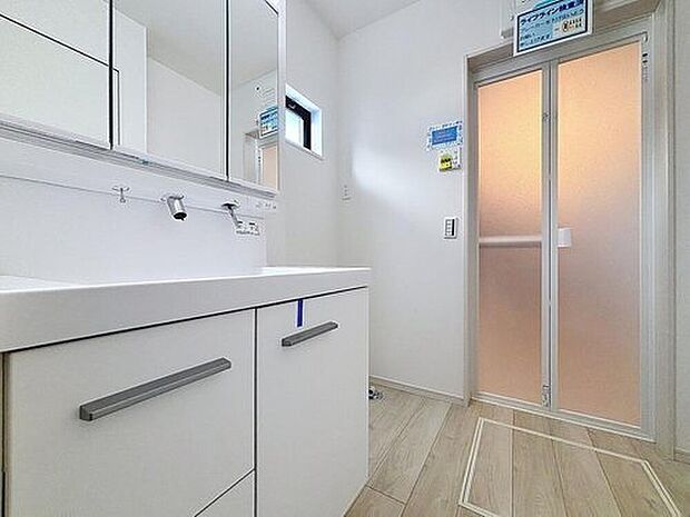 【洗面台・洗面所】明るく清潔感のある色調で纏められた洗面室は、機能性に富んだ三面鏡と使い勝手の良い収納を完備した洗面台を設置。洗濯機置場も完備し、大変充実しております。