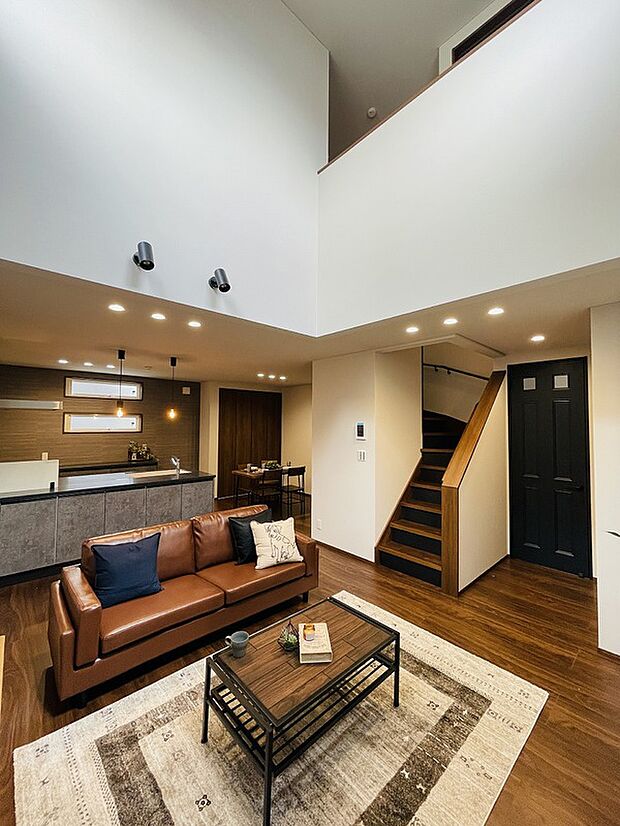 【リビング】存在感のある色合いのインテリアも吹抜けから注ぐ光によって調和されます。