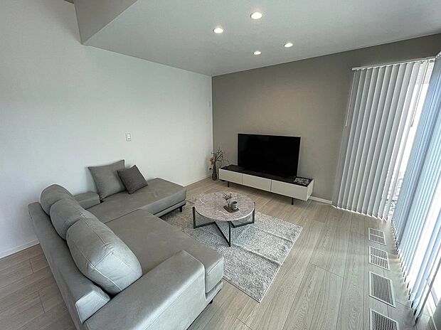 グレーを基調にブラックをアクセントとしたモダンなリビング。大きな窓から光がたっぷり入り、落ち着きと開放感を両立した空間です。