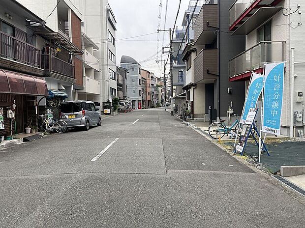 【【前面道路を含む現地写真】】東側前面道路は幅員約8.0m。ゆとりがあり、前面の建物との距離も保たれ、開放感のある住まいを実現できます。幼保、小中学校が徒歩10分圏内に揃う、子育て世帯に嬉しい住環境です◎