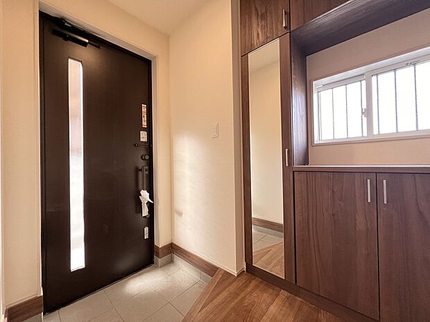 【玄関】姿見鏡付のシューズボックスを設置した明るい玄関スペース(1号棟)