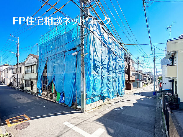 快晴の青空に映える、日当たりの良い角地の新築物件。静かな住宅街で、これから完成する理想の住まいへの期待が高まります。