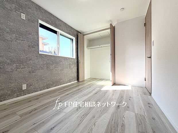 【2面採光・クローゼット付きの洋室】6帖の主寝室はアクセントクロスを採用し、シックな印象を生み出します。全居室2面採光、クローゼット付。