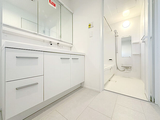 【洗面室・洗面台】ゆとりあるスペースに設けられた洗面台は、横幅の広いカウンターと大きなミラーが空間に開放感をもたらし、まるでホテルライクな上質さを感じさせる仕上がりに。毎日の身支度が心地よくなる洗面空間です。