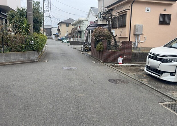 【前面道路含む現地写真_2】前面道路の幅員や歩道の有無、近隣の建物との距離感などは、実際の生活の利便性や安全性に大きく影響します。複数のアングルから前面道路の状況を確認することで、より具体的に生活イメージを描けます。