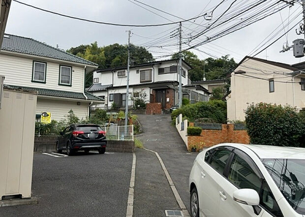 【前面道路含む現地写真_2】前面道路の幅員や歩道の有無、近隣の建物との距離感などは、実際の生活の利便性や安全性に大きく影響します。複数のアングルから前面道路の状況を確認することで、より具体的に生活イメージを描けます。