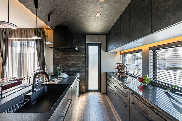 【キッチン】T-1／クリナップのステディアを採用。大容量のカップボードや勝手口を備えた機能的な設計が、日常をスマートに支えます。黒を基調とした洗練美が暮らしを彩り、家事の時間さえも優雅に包み込むキッチン空間です。